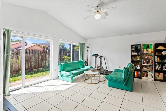 a living room with furniture and a large window with bookshelf