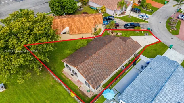 an aerial view of a tennis ground and a cars park