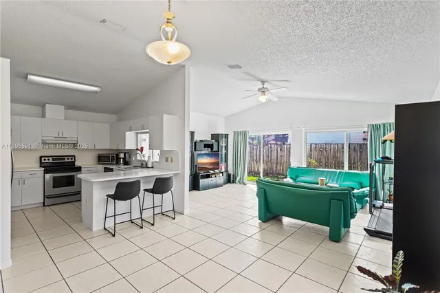 a living room with stainless steel appliances kitchen island granite countertop furniture and a view of kitchen