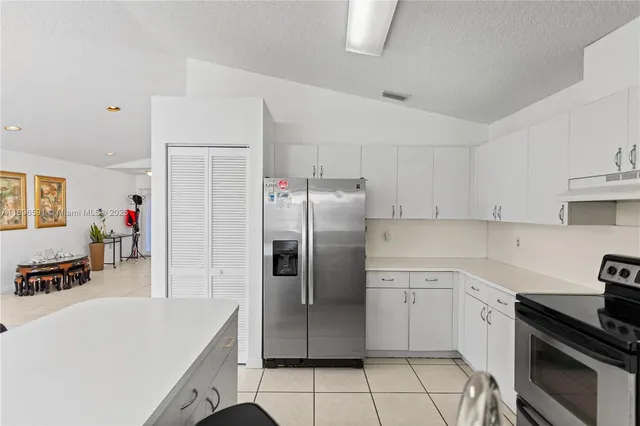 a kitchen with a sink a refrigerator and cabinets