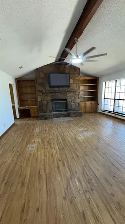 a view of empty room with wooden floor and windows
