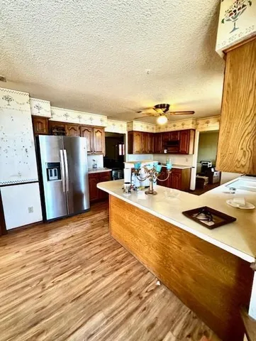 a kitchen with stainless steel appliances kitchen island granite countertop a sink and a refrigerator