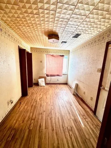 a view of a room with wooden floor and furniture