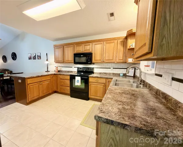 a kitchen with stainless steel appliances granite countertop a sink and a stove