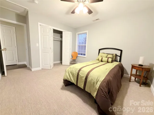 a spacious bedroom with a bed and a chandelier