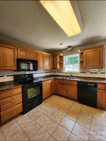 a large kitchen with granite countertop a stove top oven a sink dishwasher granite counter tops and a window