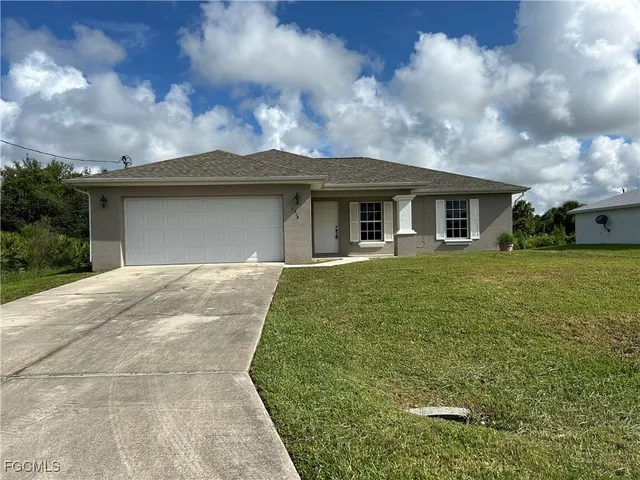 a front view of house with yard and green space