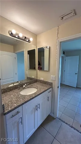 a bathroom with a granite countertop sink and a mirror