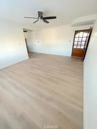an empty room with windows and fan