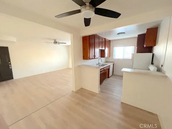 a view of a kitchen with wooden floor and stainless steel appliances