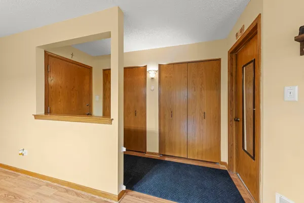 an entryway with wooden floor and a window