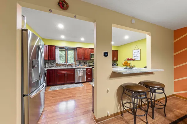 a kitchen with stainless steel appliances kitchen island granite countertop a refrigerator and a stove top oven