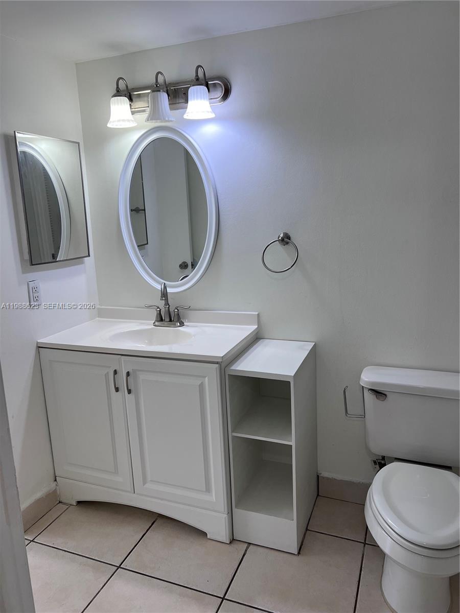 2750 West 76th Street, Unit 208 Hialeah, FL 33016 - Photo 9 of 10 a bathroom with a toilet sink and mirror