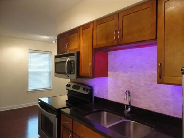 a kitchen with a sink cabinets and wooden floor