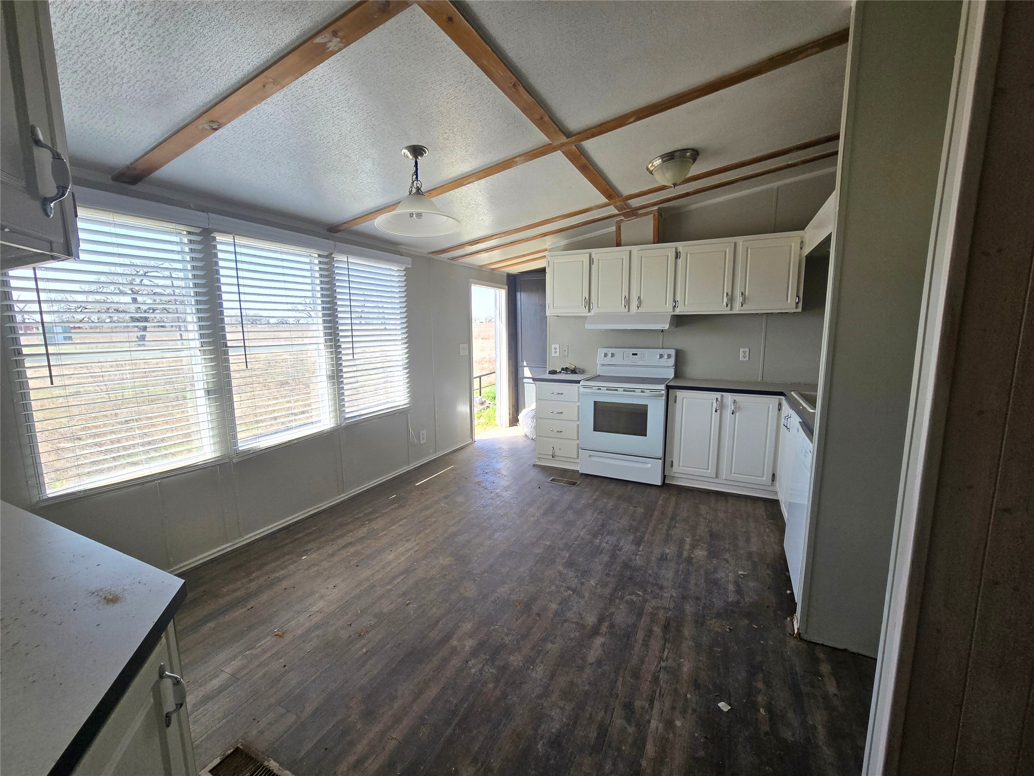 4254 FM 180 Road Ledbetter, TX 78946 - Photo 9 of 17 a kitchen with stainless steel appliances kitchen island granite countertop a stove a sink and white cabinets with wooden floor