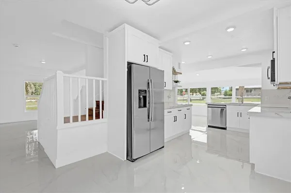 a kitchen with white cabinets and stainless steel appliances