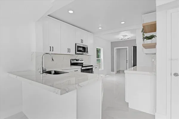 a large white kitchen with cabinets