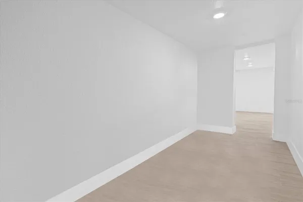 an empty room with wooden floor and white walls