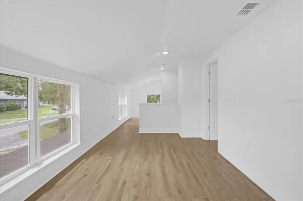 an empty room with wooden floor and window