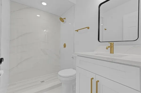 a bathroom with a double vanity sink toilet mirror and window