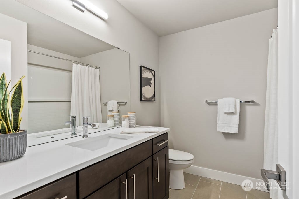 825 238th Place Southeast, Unit B8 Bothell, WA 98021 - Photo 28 of 32 a bathroom with a granite countertop sink a toilet and a mirror