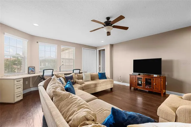 a living room with furniture a flat screen tv and a floor to ceiling window