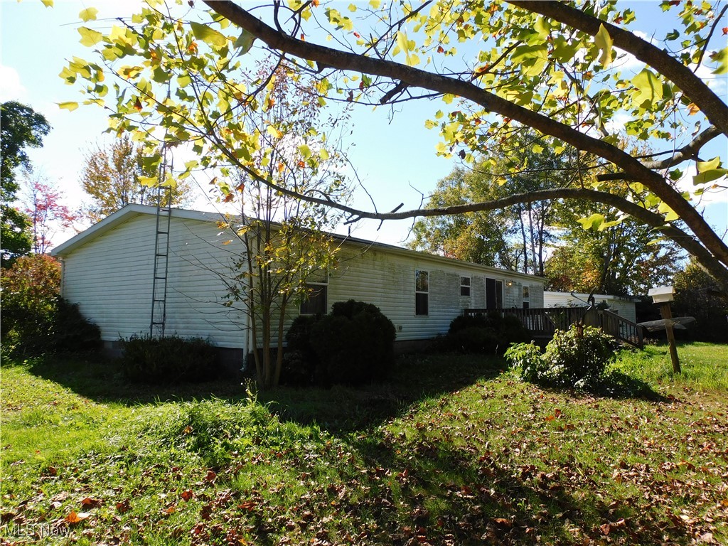 5059 Leon Road Andover, OH 44003 - Photo 5 of 18 Back of house featuring a lawn and a deck