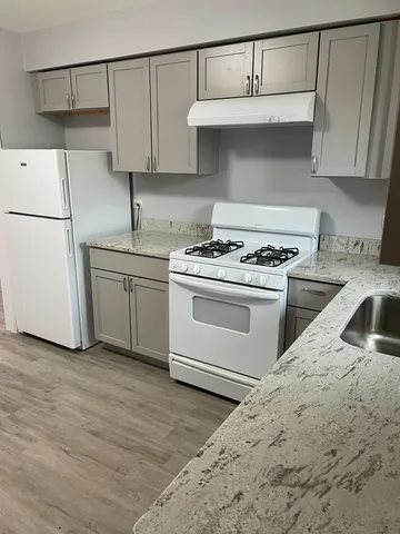 a kitchen with white cabinets and white appliances