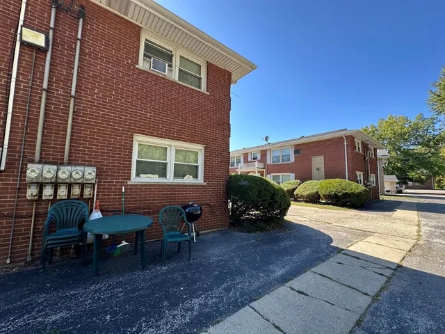 a view of a house with backyard and sitting area
