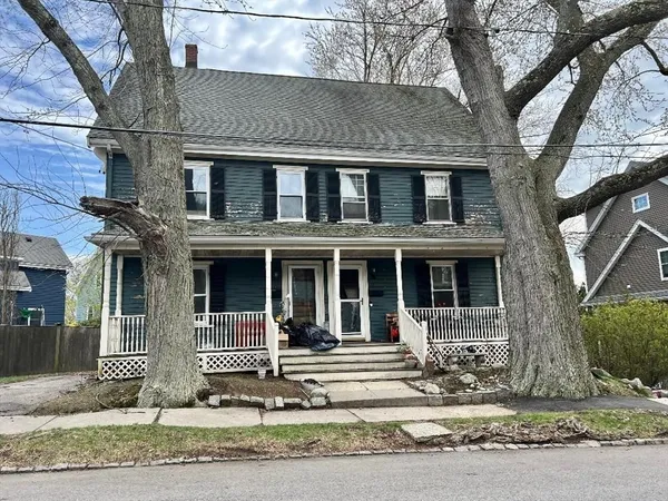 a view of a brick house with large windows and a large tree