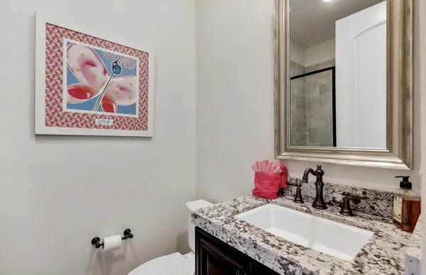 a bathroom with a granite countertop sink and a mirror
