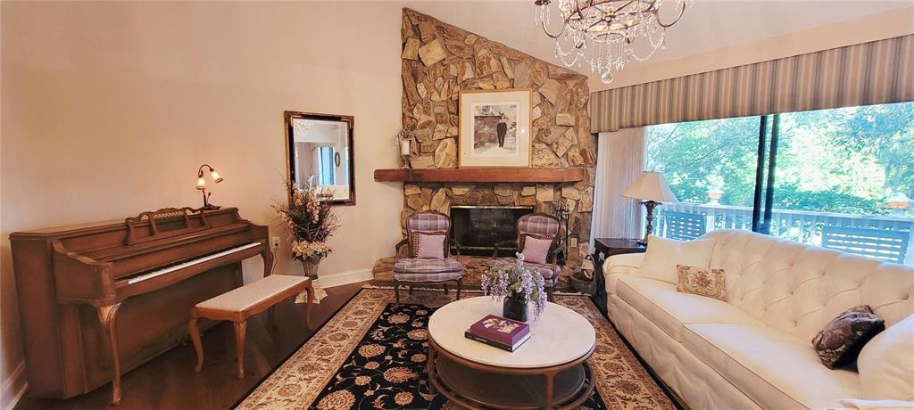 1004 Old Mill Pond Road Palm Harbor, FL 34683 - Photo 13 of 48 a living room with furniture a fireplace and a large window