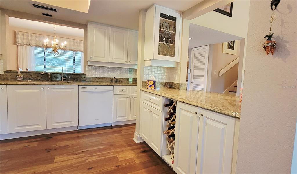 1004 Old Mill Pond Road Palm Harbor, FL 34683 - Photo 18 of 48 a kitchen with stainless steel appliances granite countertop a sink and cabinets with wooden floor