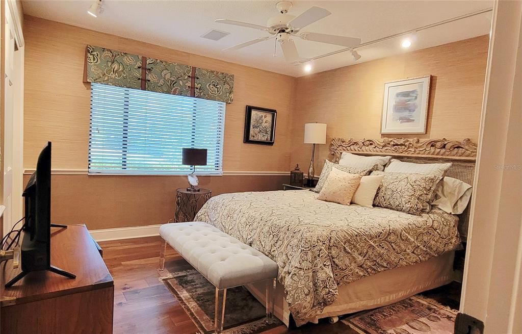 1004 Old Mill Pond Road Palm Harbor, FL 34683 - Photo 26 of 48 a bedroom with a large bed and a flat screen tv