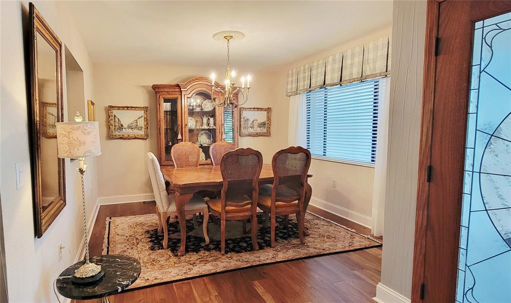 1004 Old Mill Pond Road Palm Harbor, FL 34683 - Photo 8 of 48 a view of a dining room with furniture window and wooden floor