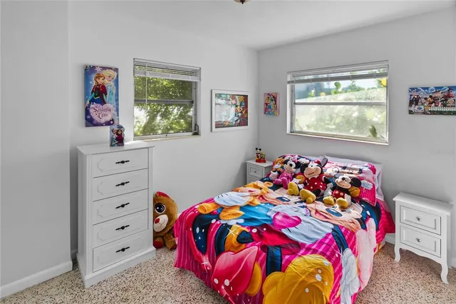 a bedroom with two beds and a large window