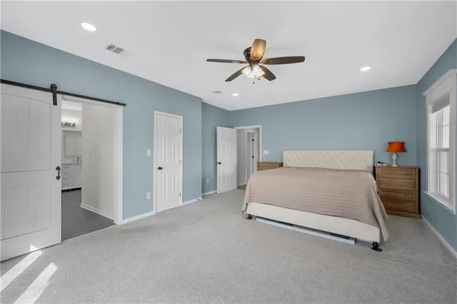a spacious bedroom with a bed and a chandelier