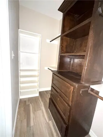 a view of walk in closet with clothes and shoes