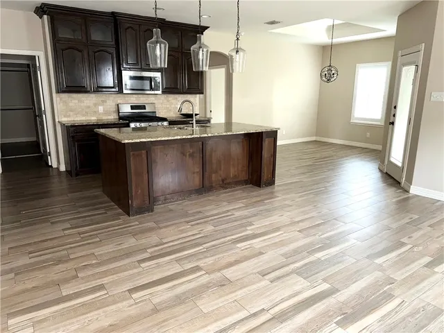 a kitchen with stainless steel appliances granite countertop a sink stove and refrigerator