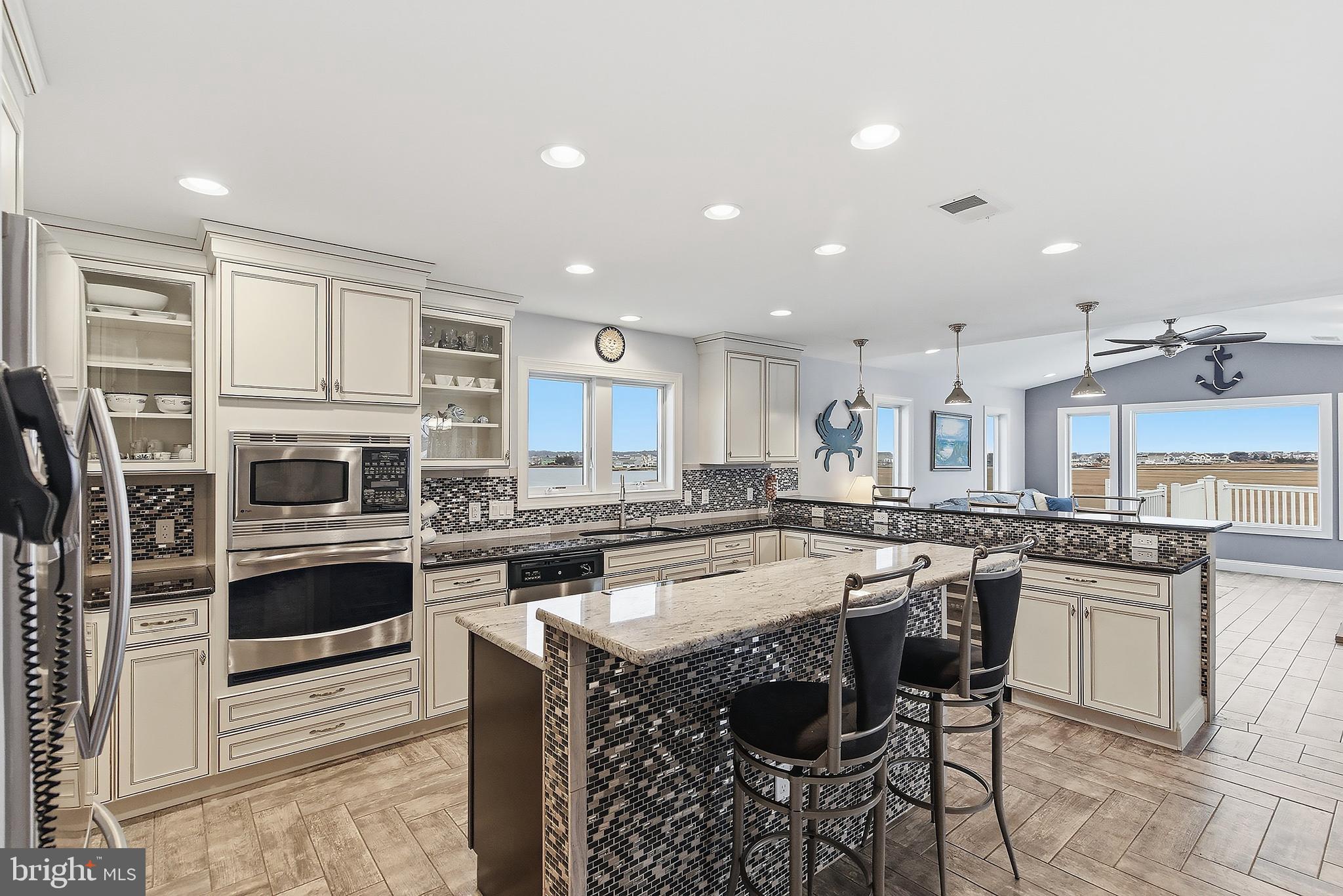 23 East Pimlico Road Little Egg Harbor, NJ 08087 - Photo 27 of 43 a kitchen with stainless steel appliances granite countertop a stove top oven a sink a dining table and chairs
