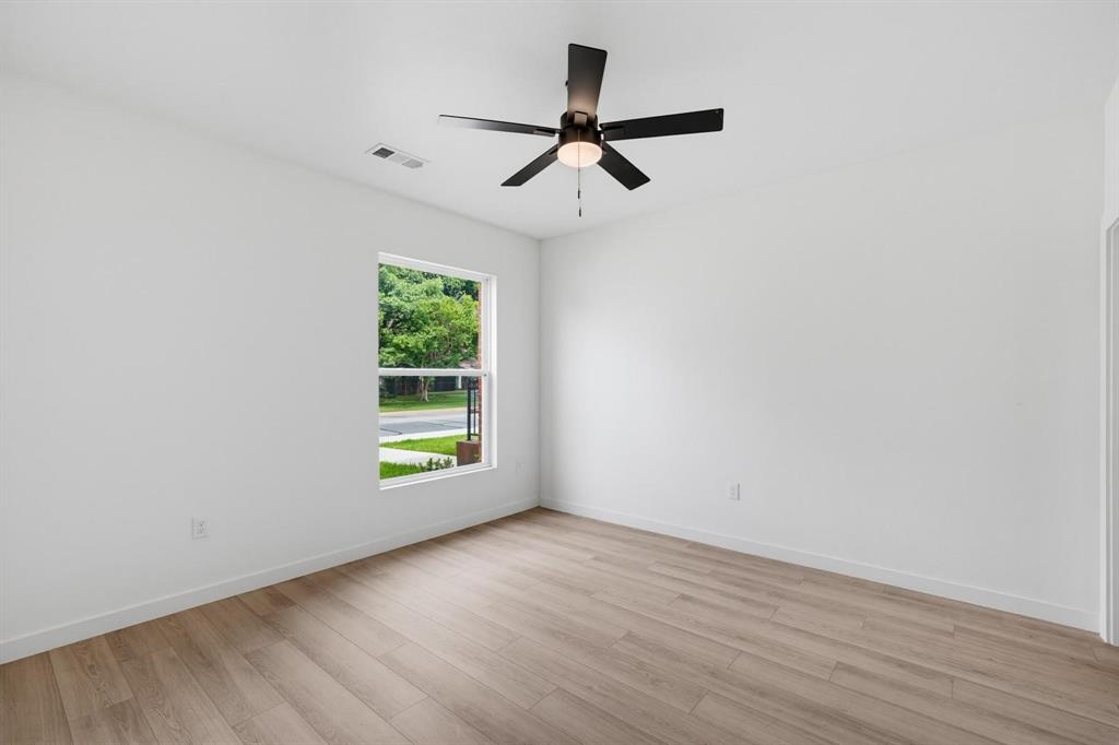 510 South O Connor Road Irving, TX 75060 - Photo 6 of 22 Room featuring wood-finish flooring, white walls, and a modern black ceiling fan with integrated lighting