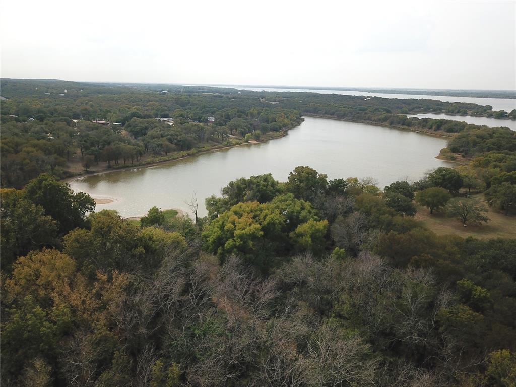 0 Hudson Drive Valley View, TX 76272 - Photo 1 of 15 Aerial view of property and surrounding area with a heavily wooded area and a nearby body of water