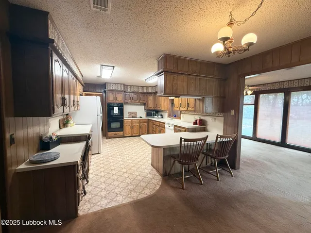 a large kitchen with kitchen island a sink stainless steel appliances and cabinets
