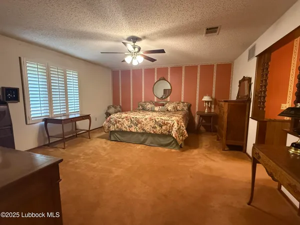 a bedroom with a large bed and dresser