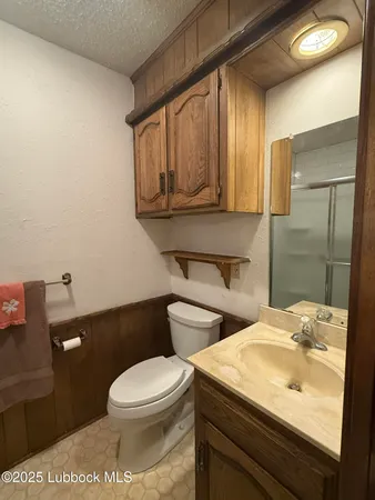 a bathroom with a granite countertop shower and a toilet