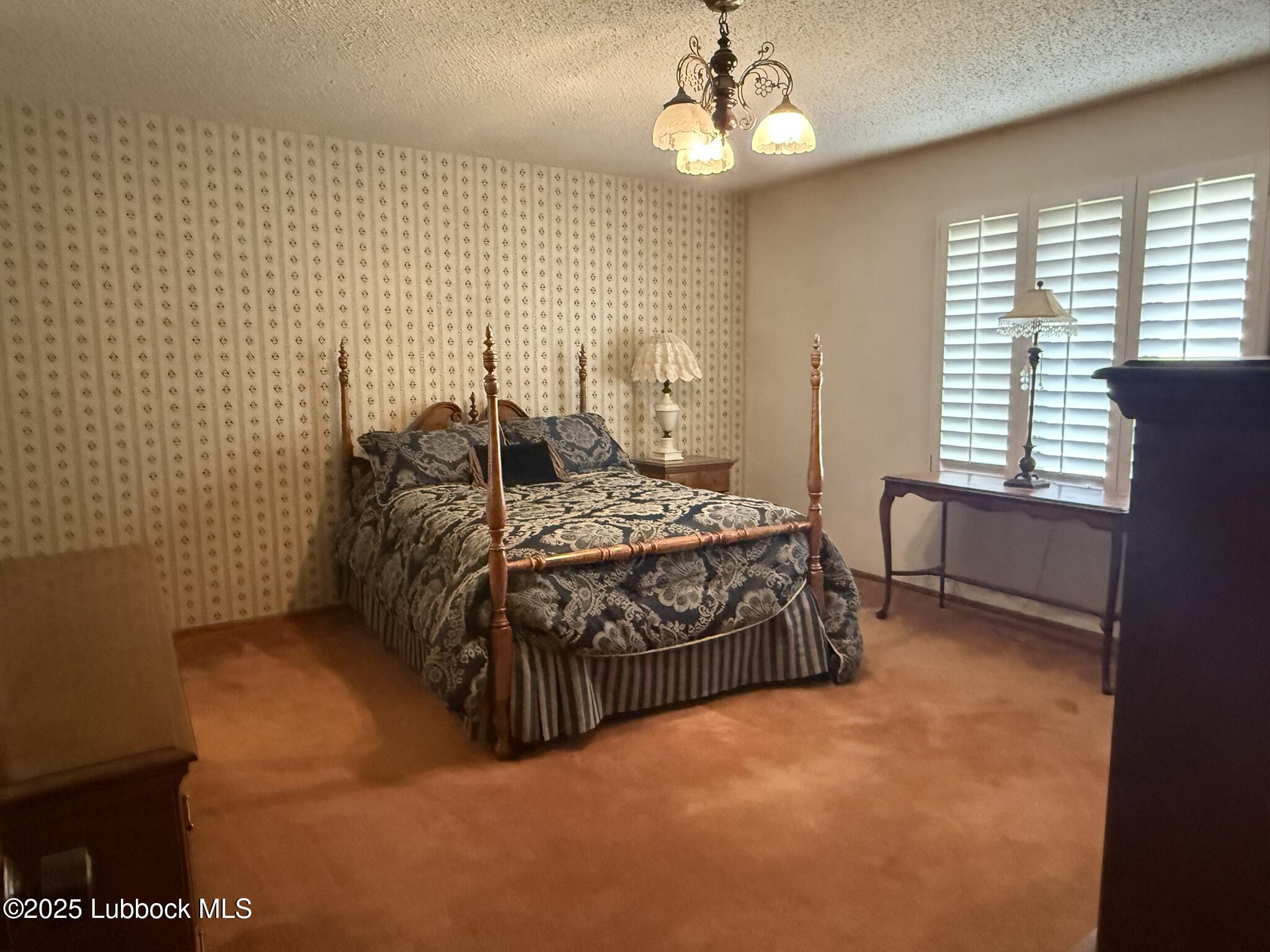 101 Dana Avenue Earth, TX 79031 - Photo 23 of 29 a bedroom with a bed chandelier and a window