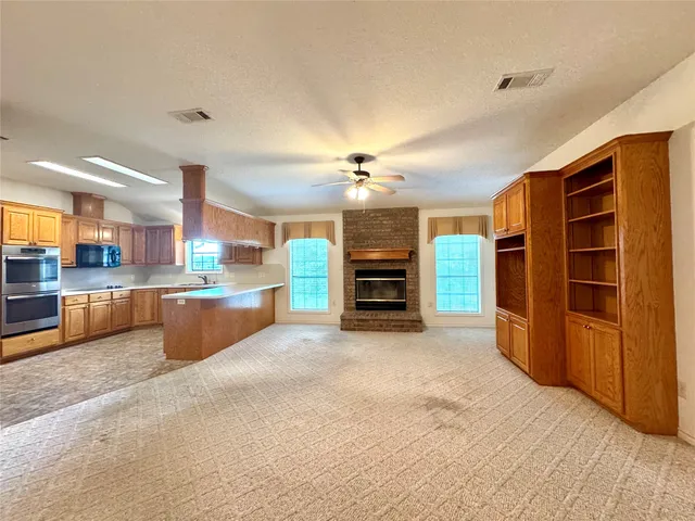 a view of an empty room and kitchen