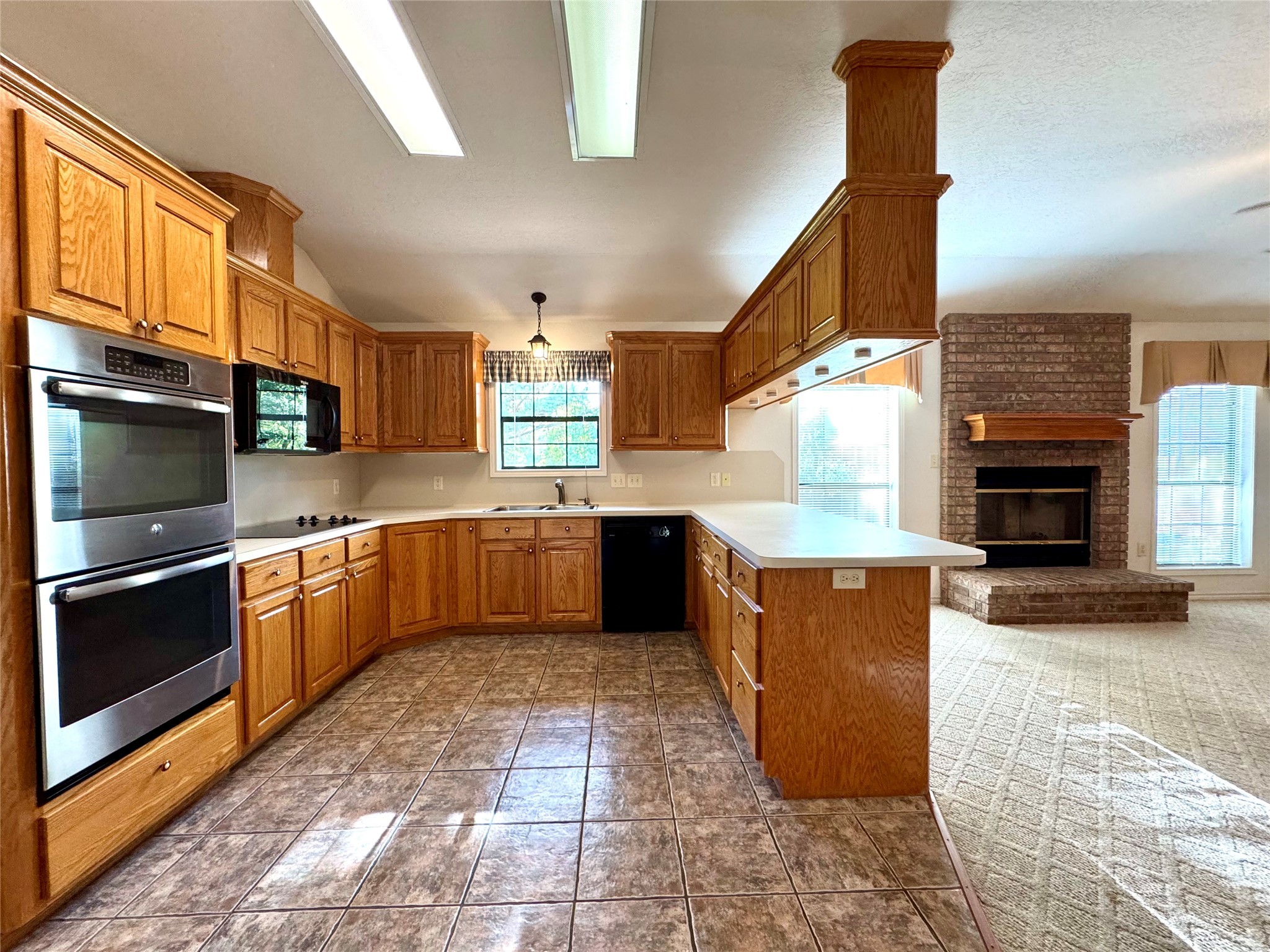 20 Shallow Springs Trinity, TX 75862 - Photo 23 of 48 a kitchen with stainless steel appliances kitchen island granite countertop a stove a sink dishwasher and a microwave oven with large wooden cabinets
