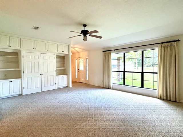 a view of a livingroom with a ceiling fan and window
