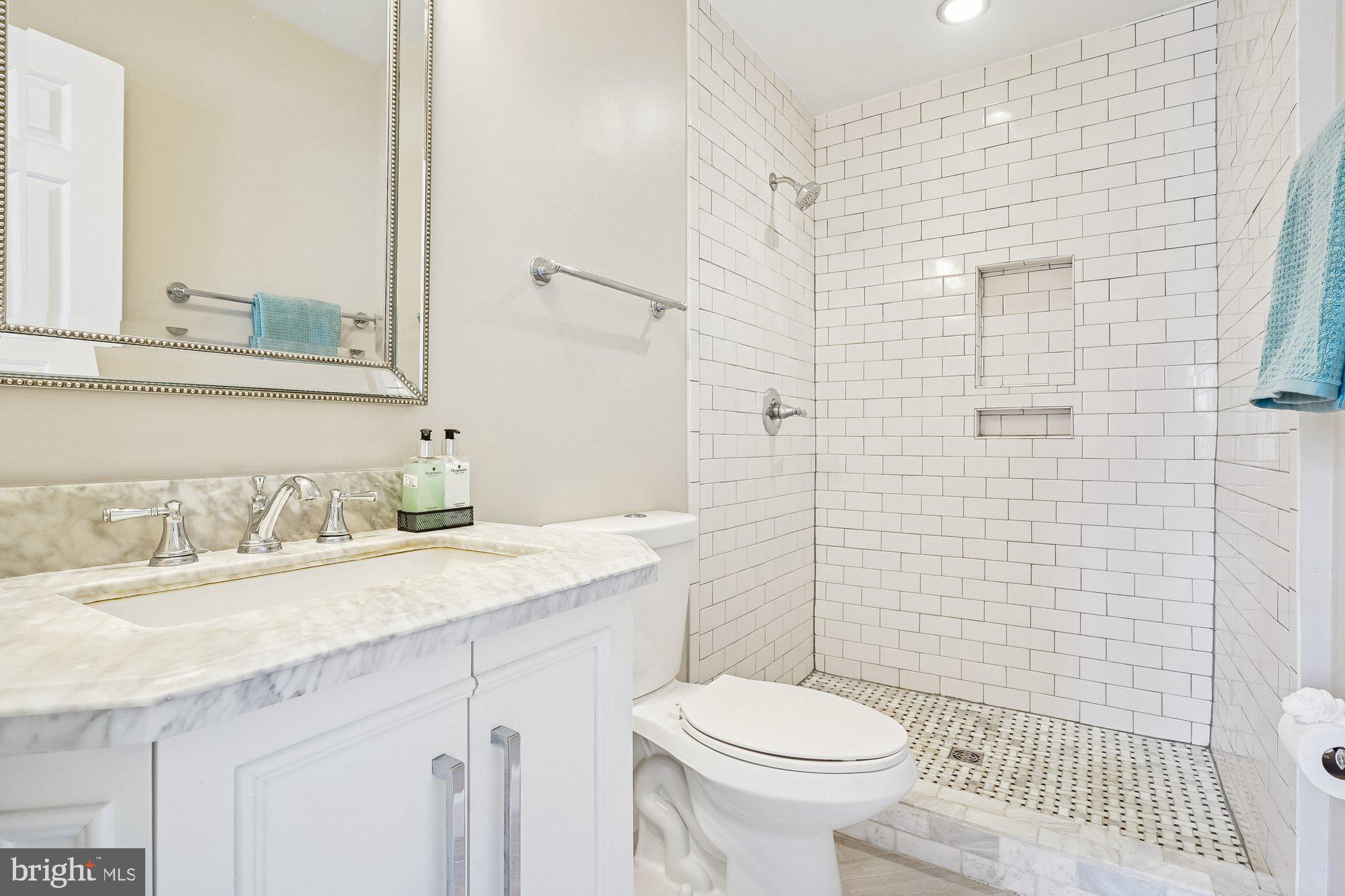 8826 Surveyors Place Springfield, VA 22152 - Photo 23 of 40 a bathroom with a granite countertop toilet sink and a mirror